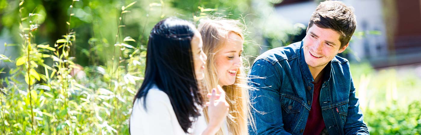 Three students smiling outside